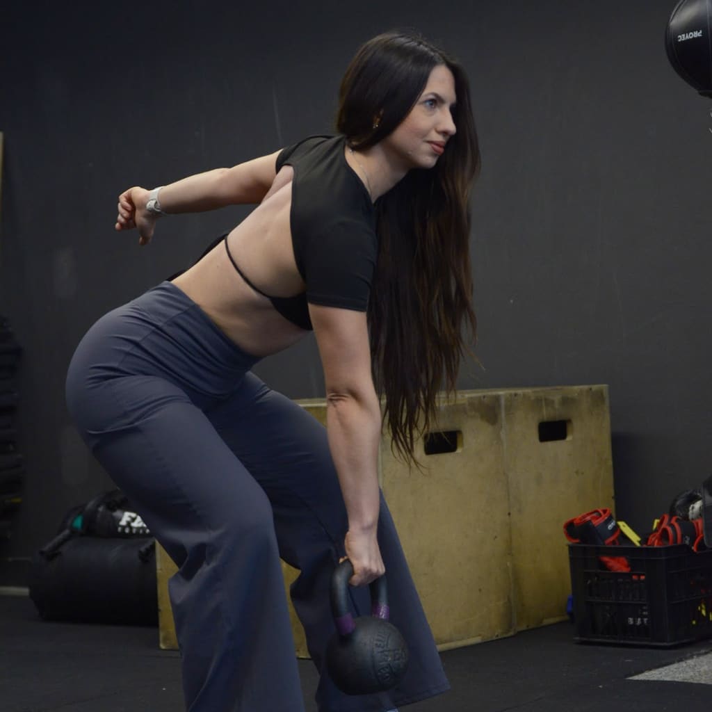 Maia Soldano entrenando con una pesa rusa en el gimnasio.